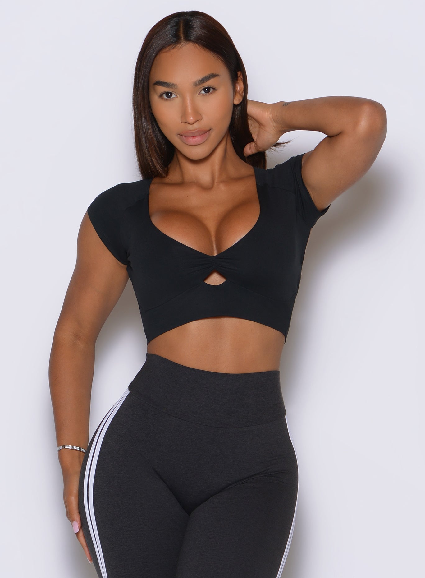 Black 360 Tee features a ruched scoop neckline and cap sleeves for flattering gym support