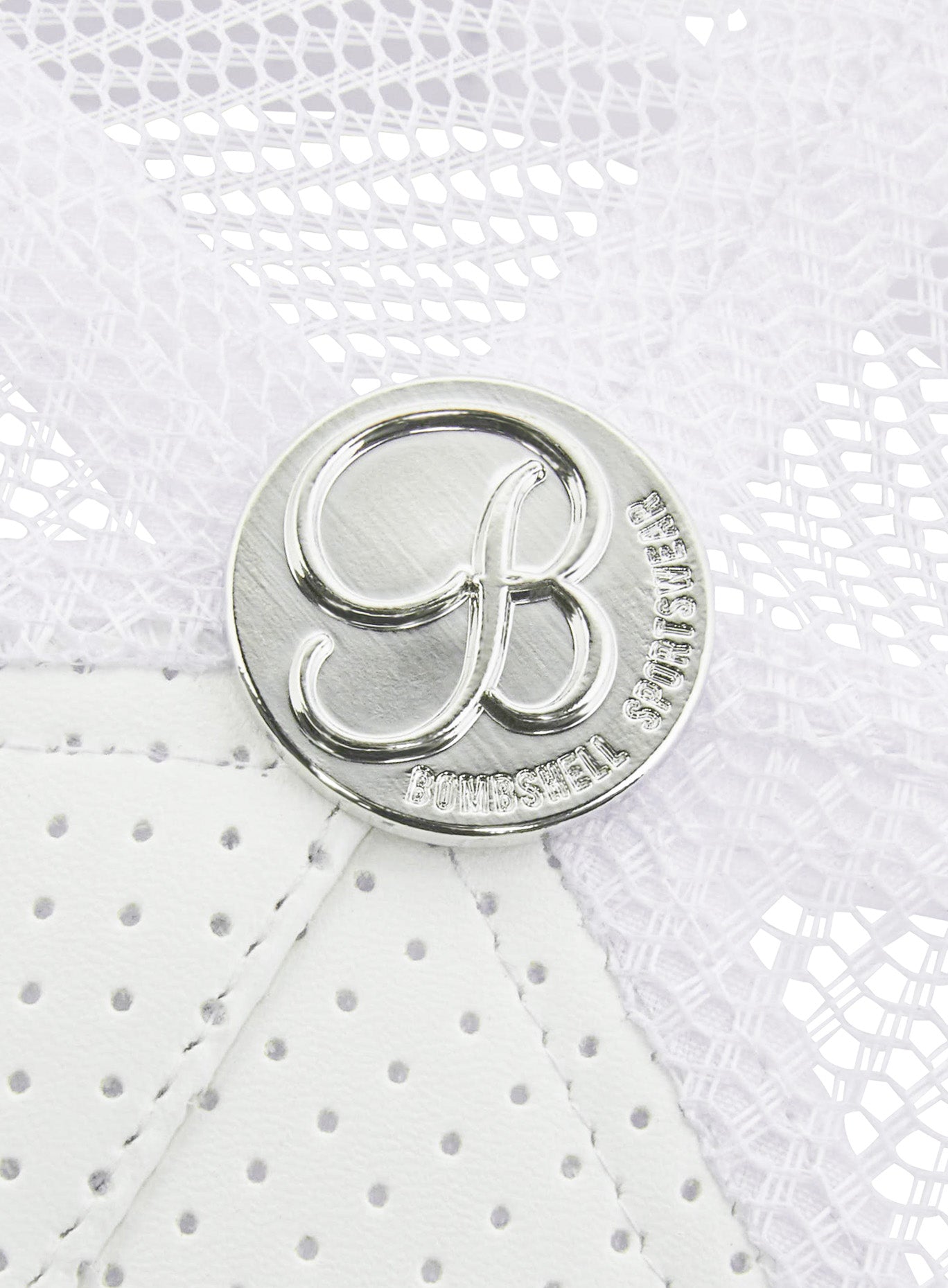 picture of the silver colored bombshell logo on the white perforated hat