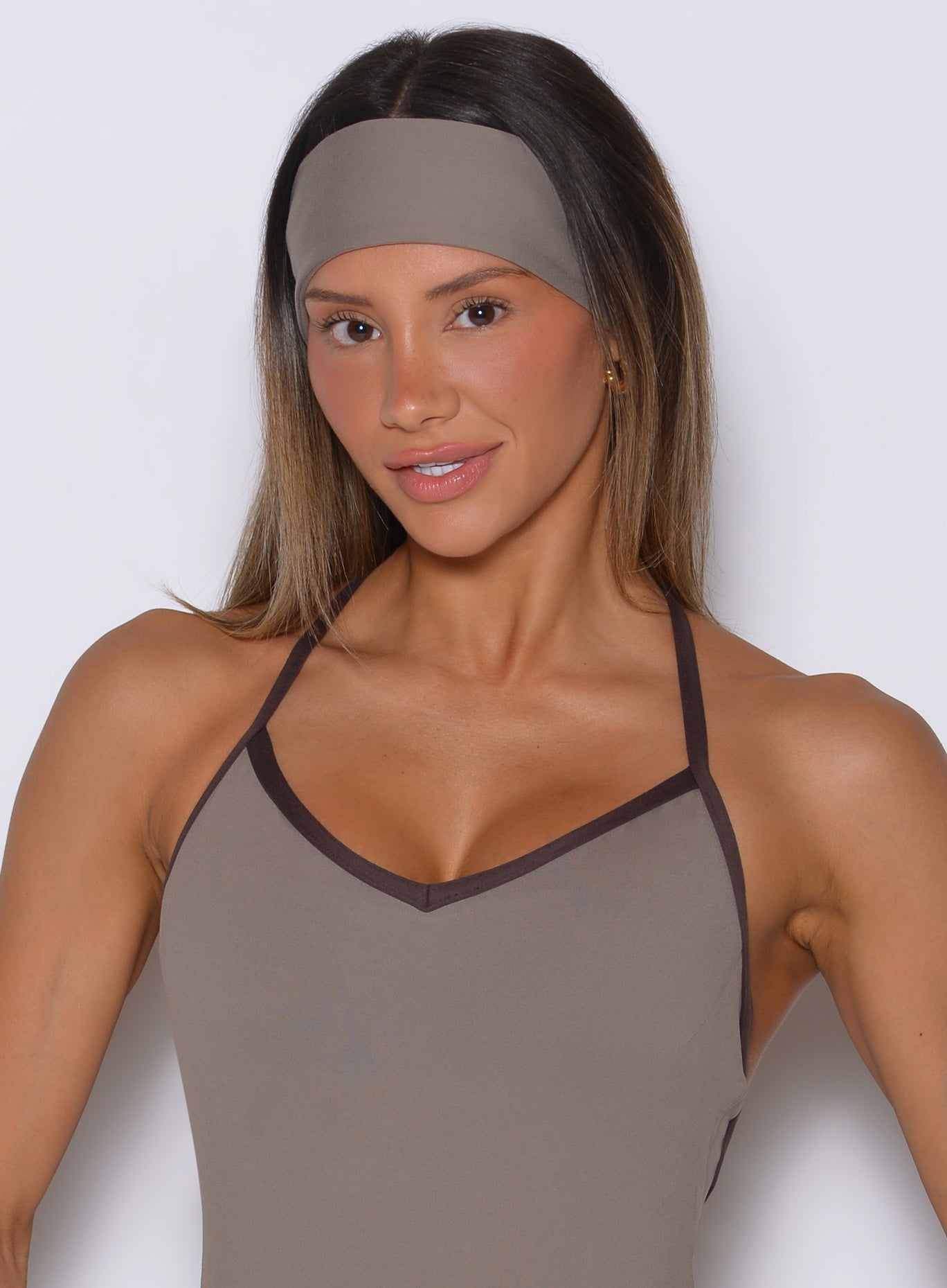 Close-up of a model in a stone B Fit Headband, a breathable and stretchy gym hair accessory.