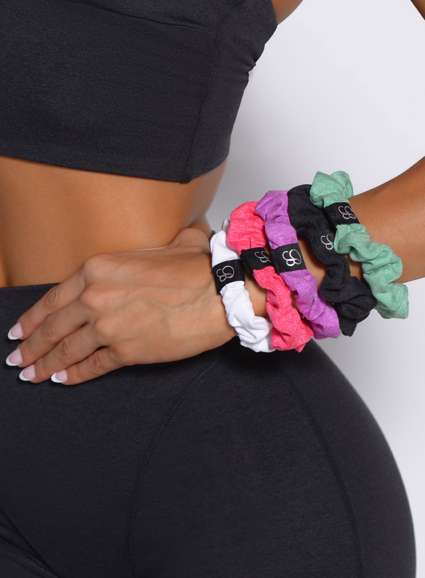 Heathered black B Scrunchie worn on a wrist, a soft and stretchy athletic hair accessory.