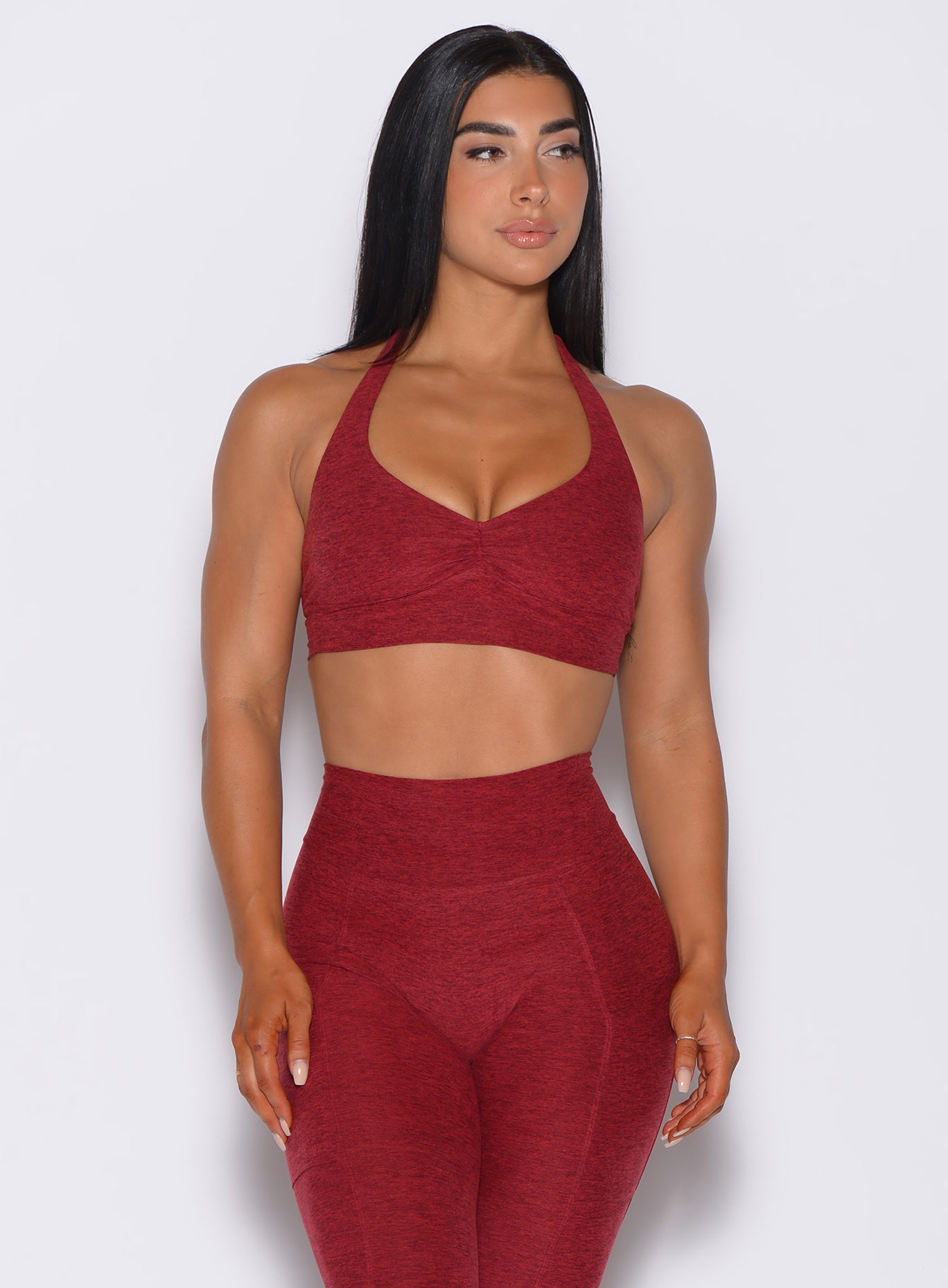 front profile view of a model wearing our Backless Bra in Garnet Red color and a matching leggings