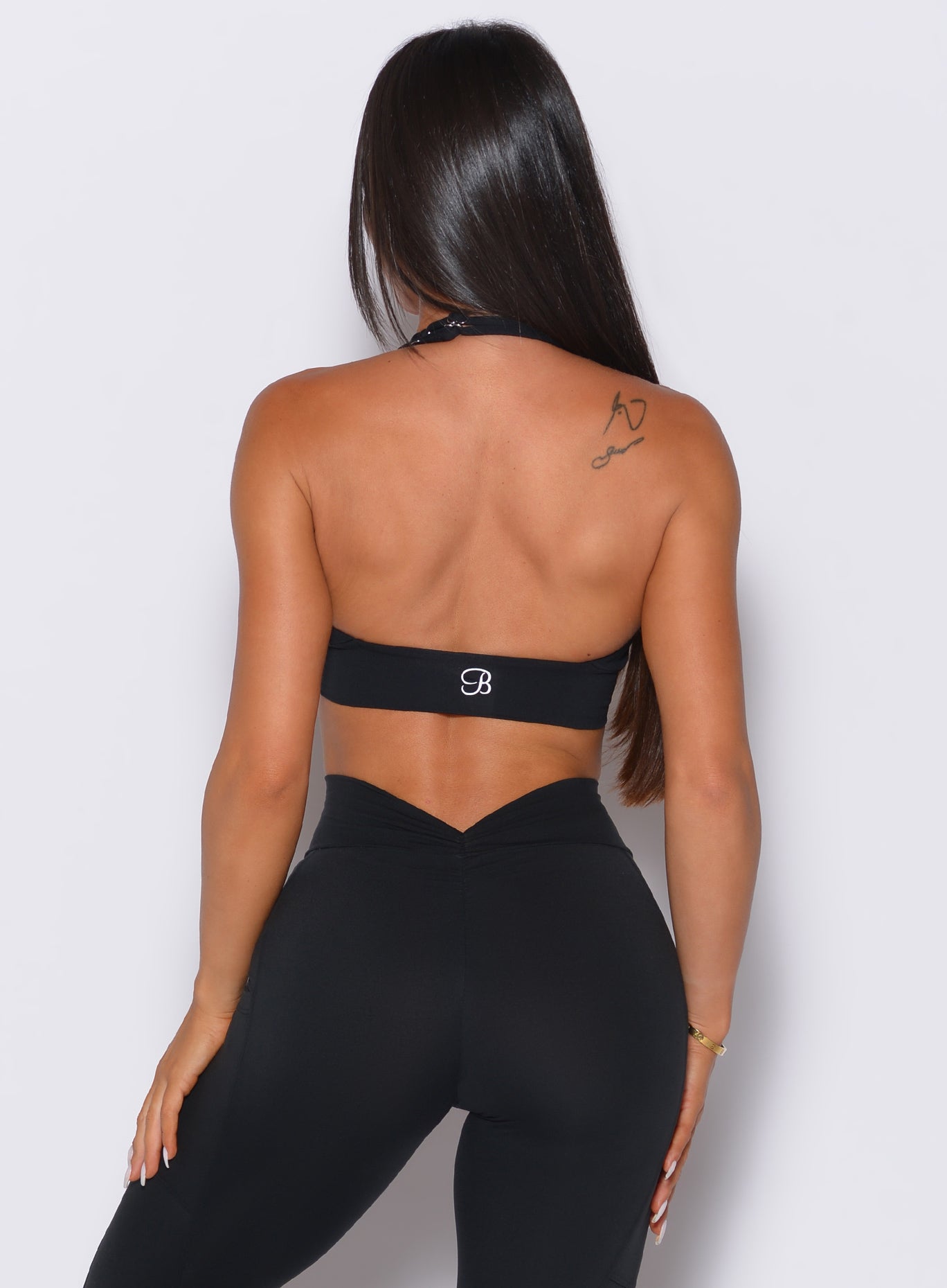 Sculpting black Backless Bra with a halter neck and open back to showcase earned gym gains.