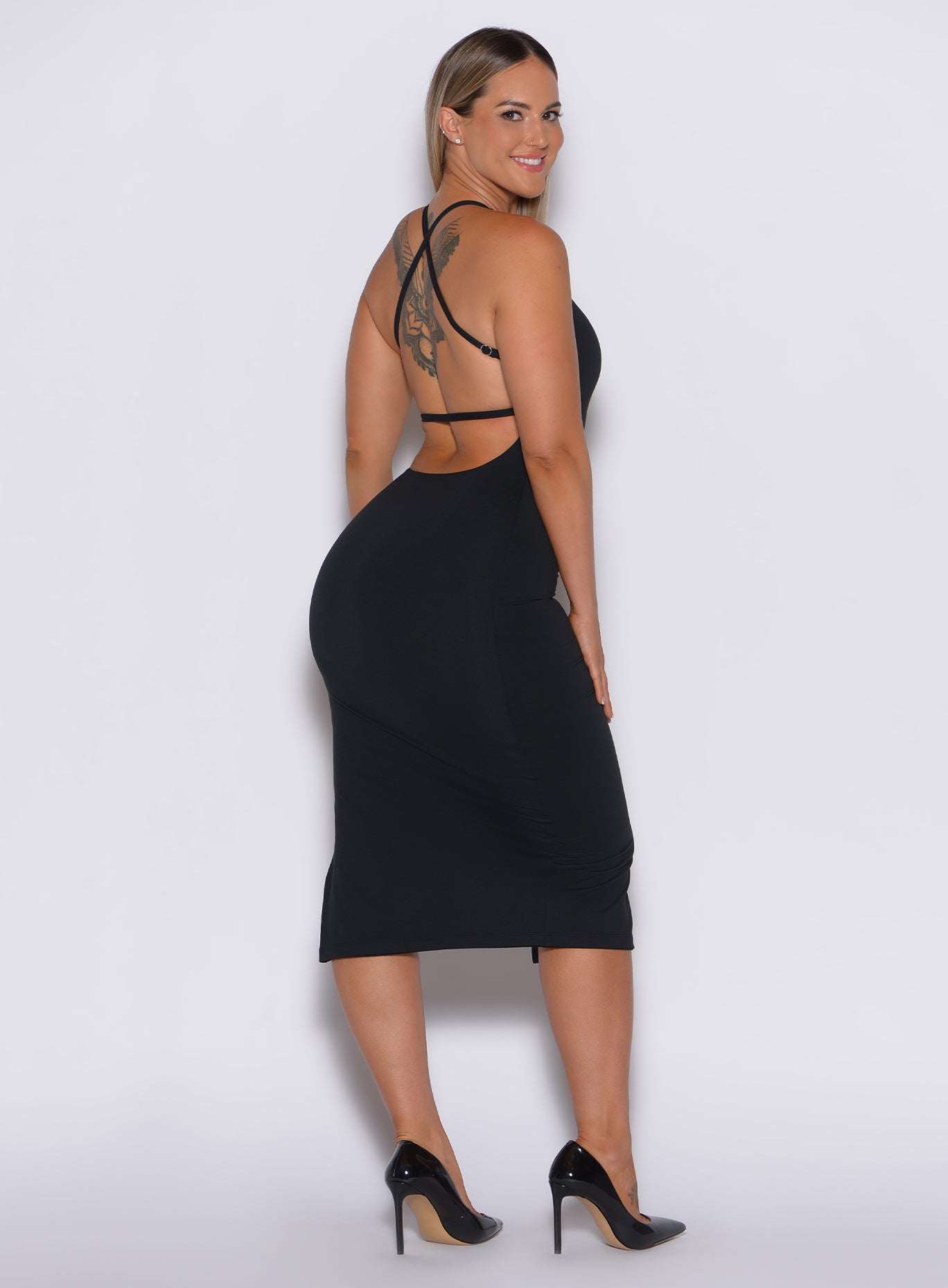 back profile picture of a model facing to her right wearing our black bombshell bunny dress