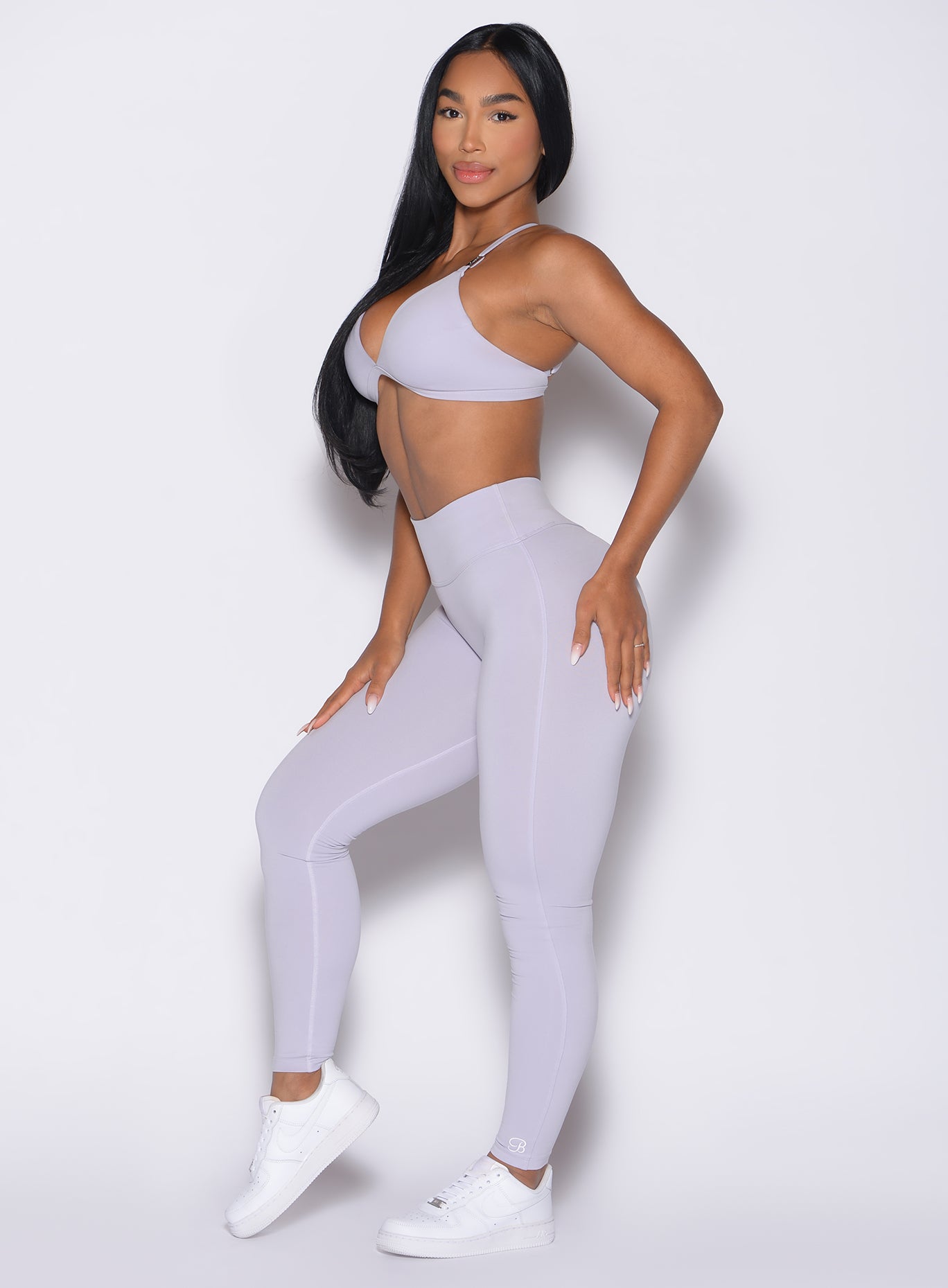 left side profile view of a model wearing the Bombshell Bunny Leggings in Galactic Lilac color