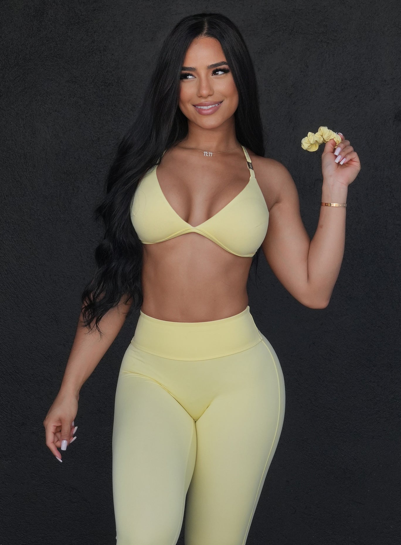 picture of a model holding a bombshell scrunchie band in light yellow color