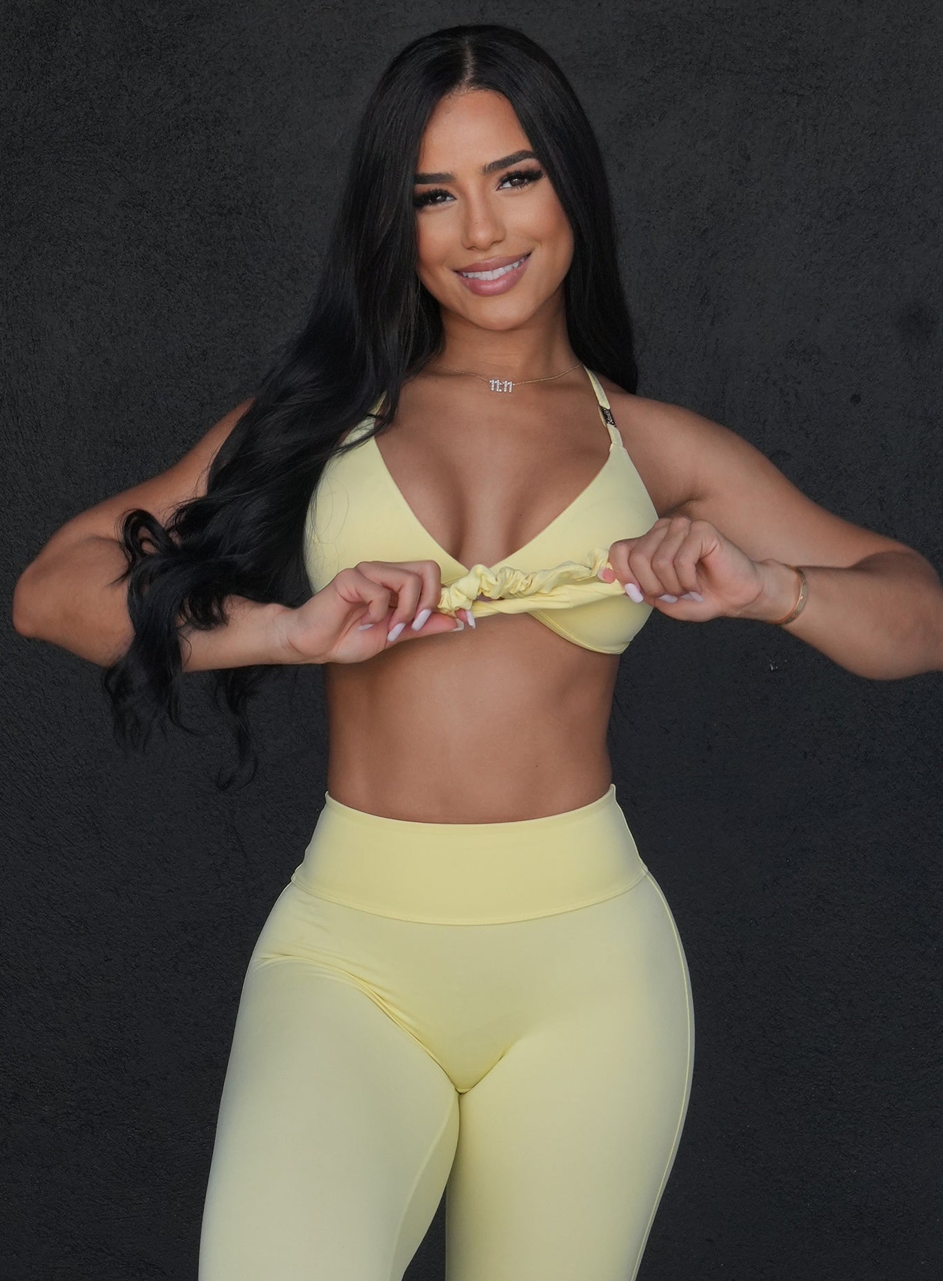 front view of a model with a scrunchie in her hands in light yellow color