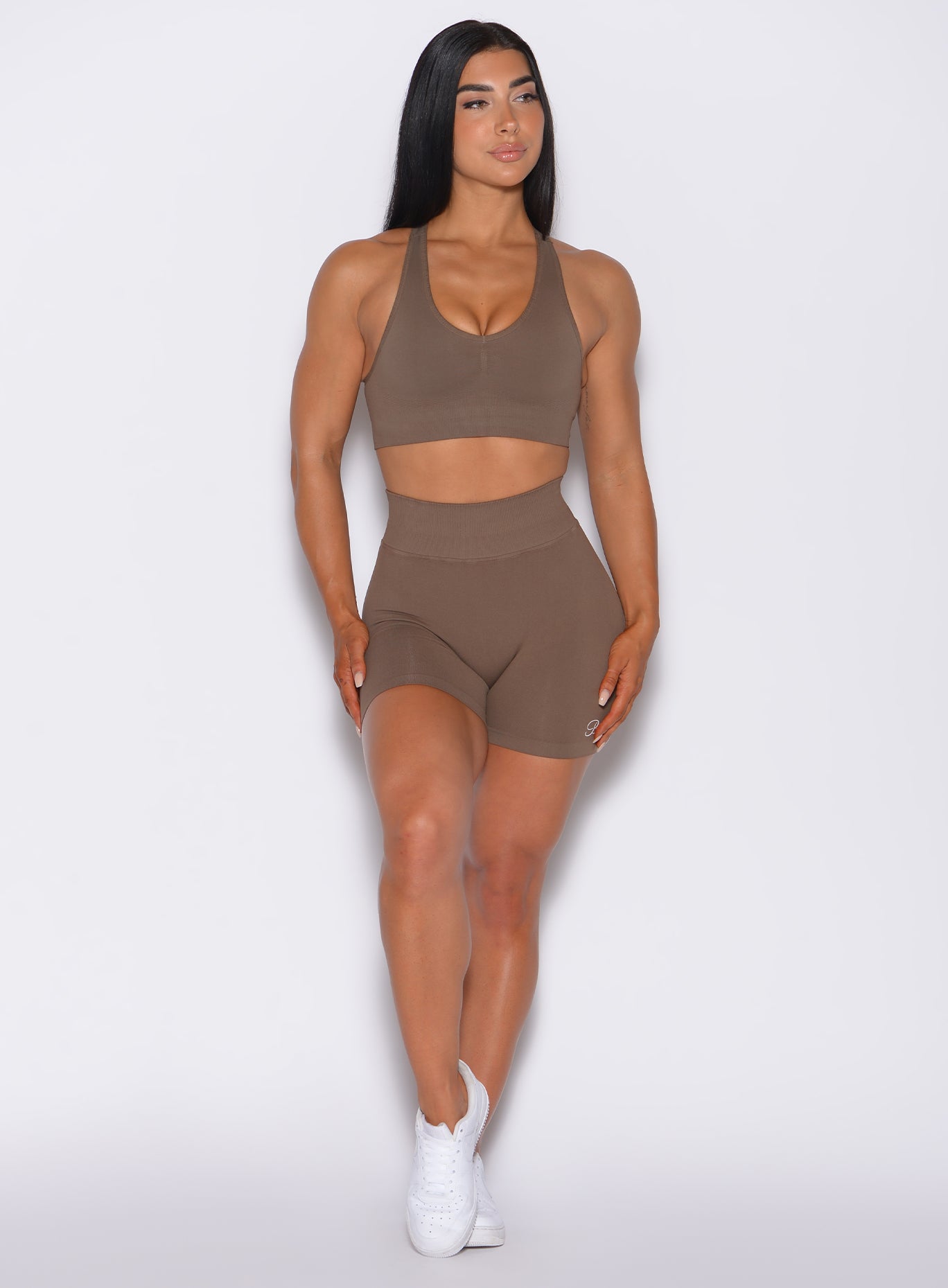 Front profile view of a model in our Cheeky Seamless Shorts in beachwood color and a matching bra