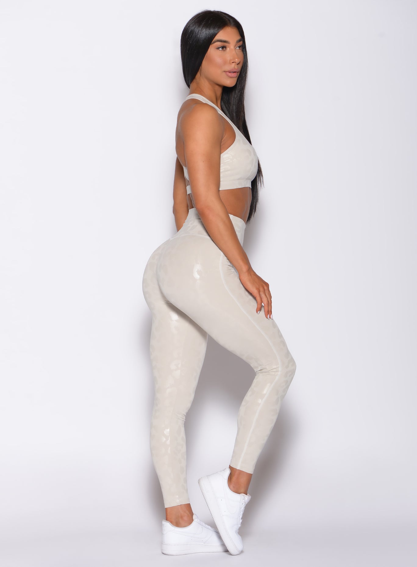 right side profile view of a model wearing our shine leopard leggings in Buff Leopard color along with the matching sports bra