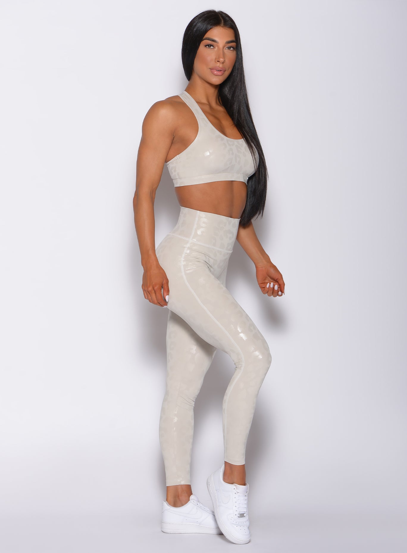 right side profile view of a model facing to her right wearing our shine leopard leggings in buff leopard color along with a matching bra