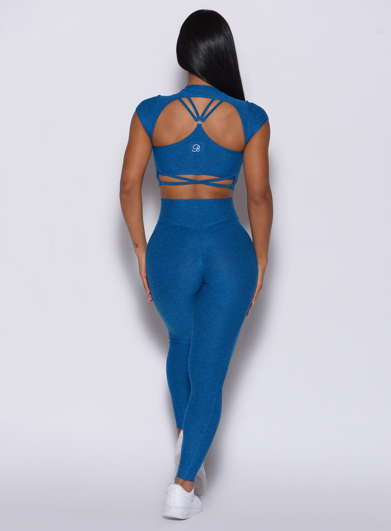 Back profile view of a model in our cloud leggings in azure color and a matching bra