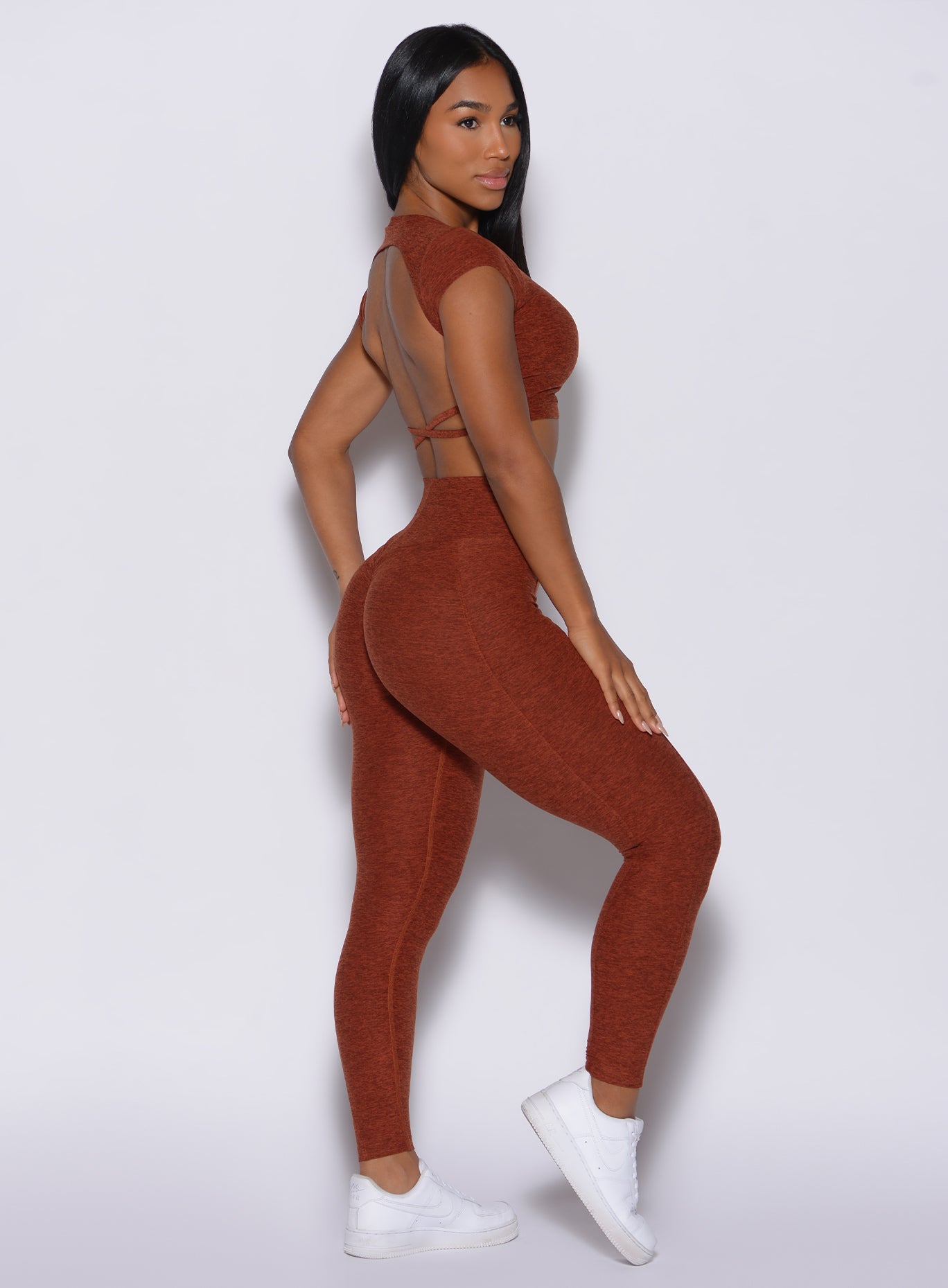 Right side profile view of a model in our cloud leggings in Cinnamon color and a matching sports bra