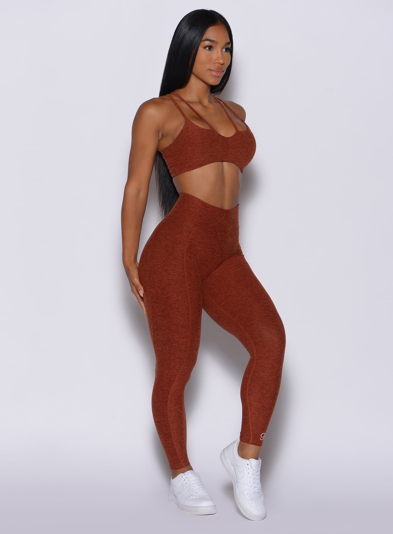 Right side profile view of a model in our cloud leggings in Cinnamon color and a matching bra
