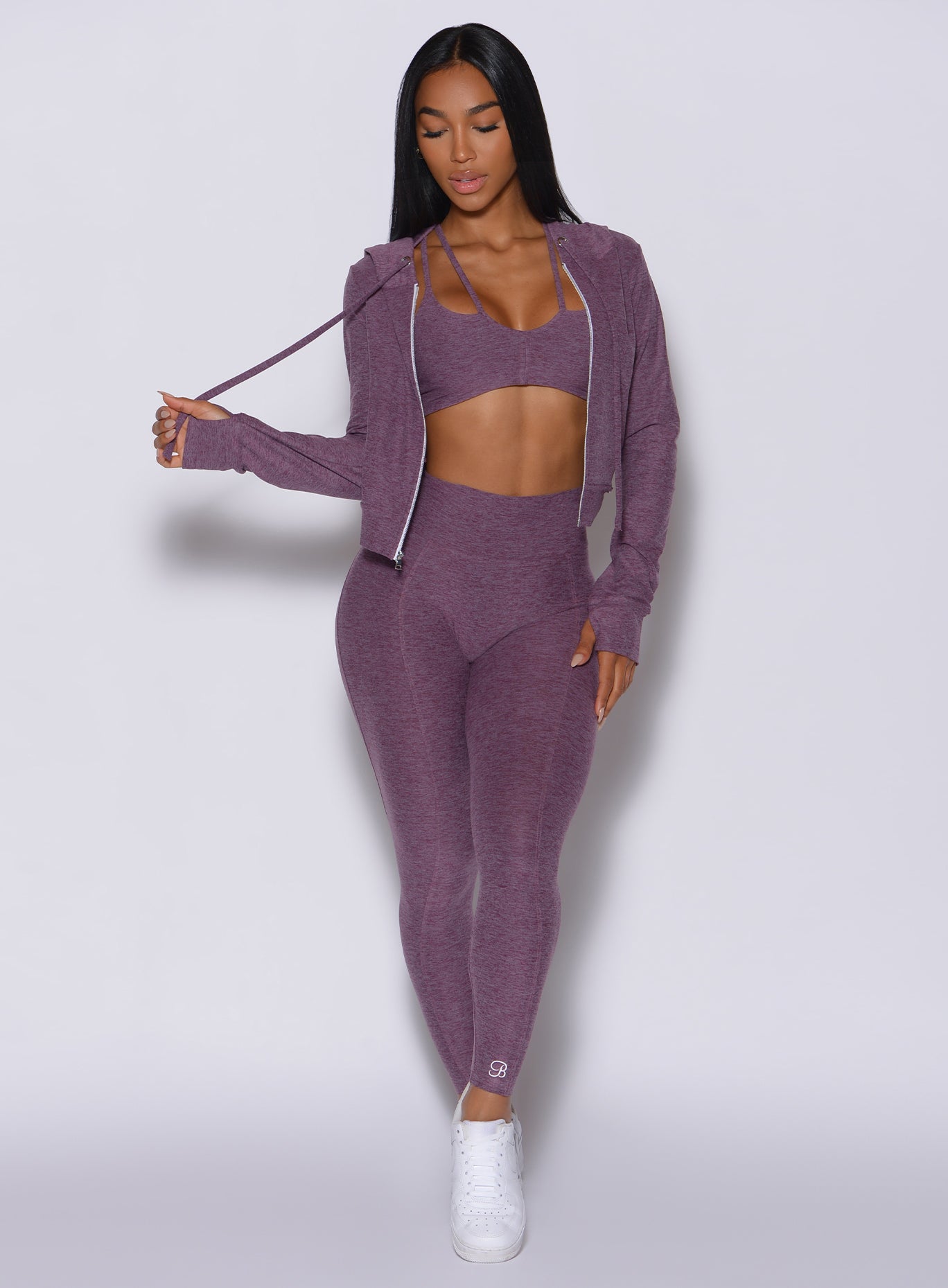Front profile view of a model in our cloud leggings in Regal Purple along with the matching bra and jacket