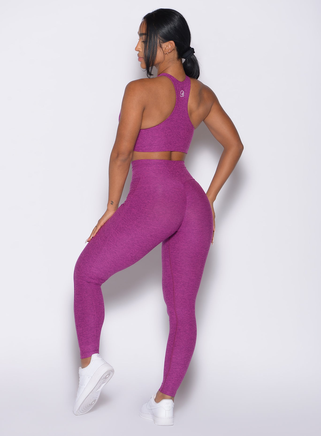 back profile view of a model wearing our Contour Leggings and the matching Cross Over Halter Bra in Bright Plum color