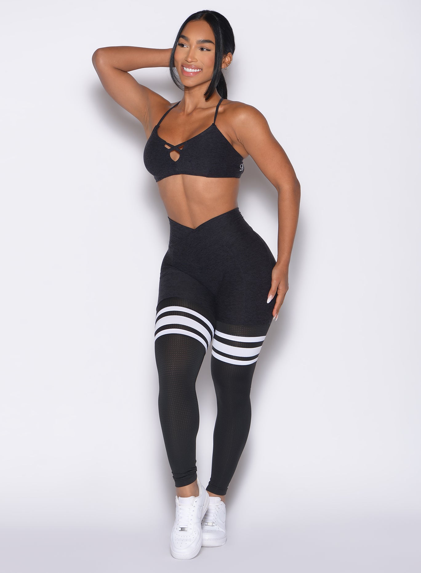 front profile view of a model looking to the right side wearing the Contour Thigh highs in heathered black color