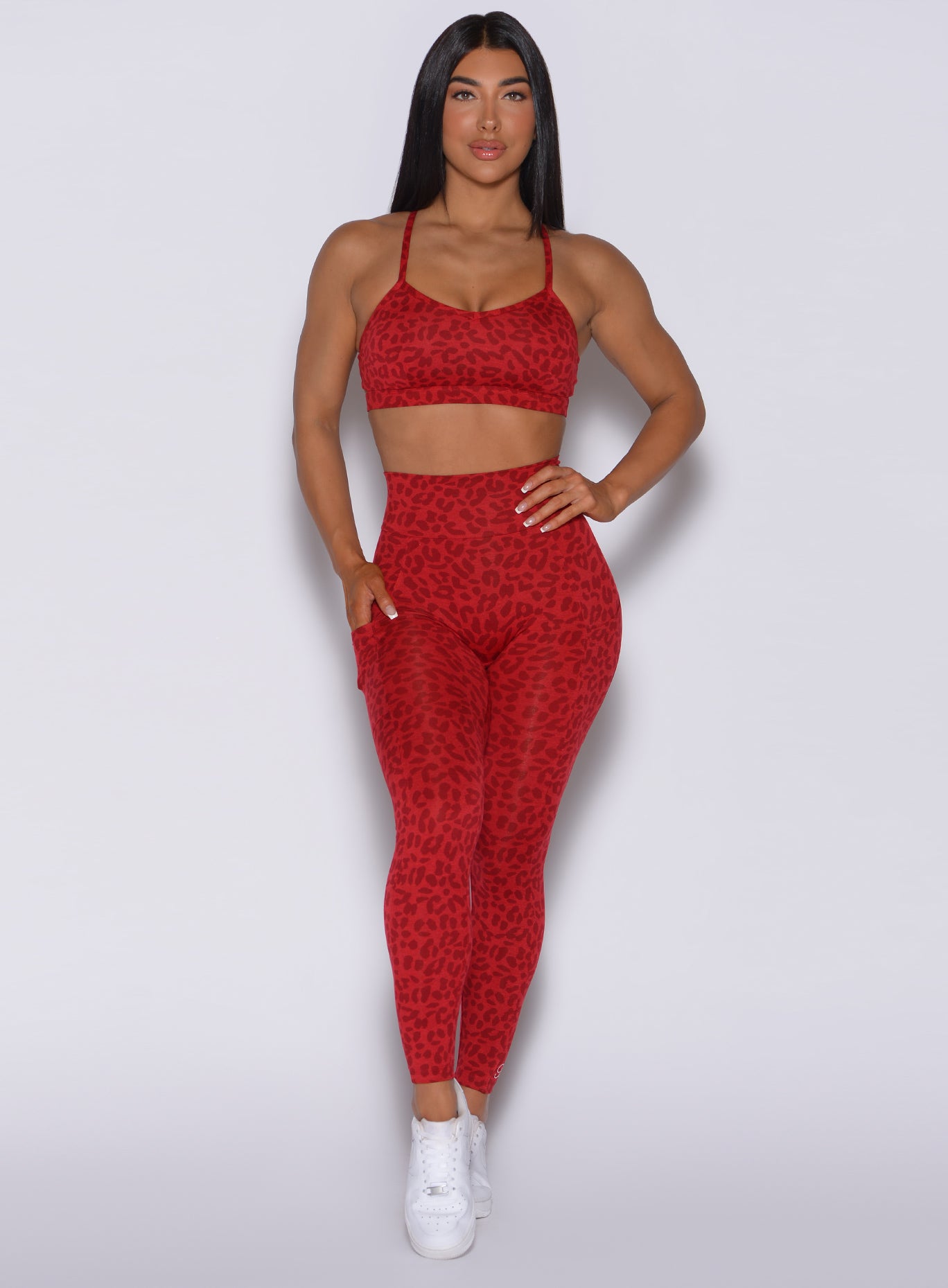 Front profile view of a model in our curves leggings in red cheetah color and a matching sports bra