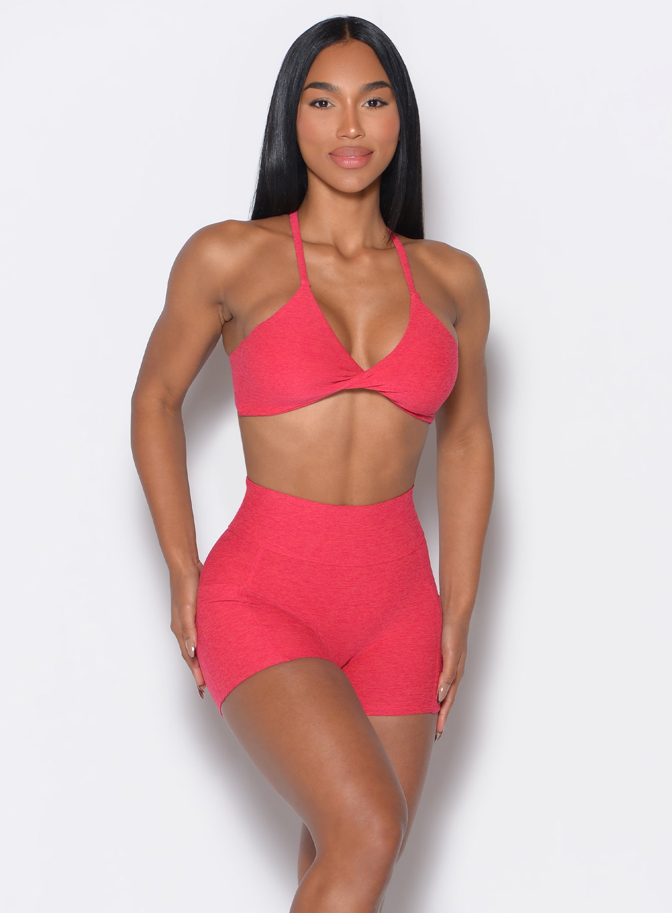 front profile view of a model facing forward wearing our twist mini bra in Raspberry Punch color along with a matching shorts