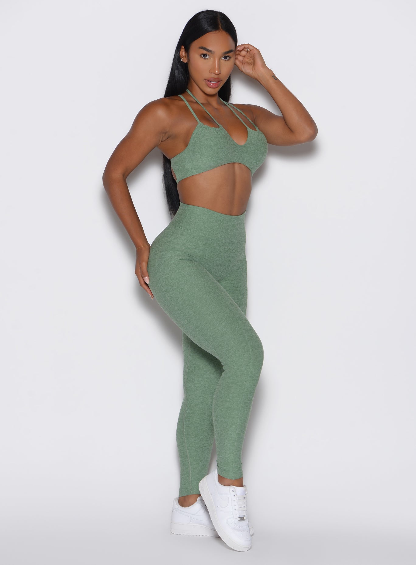 front right side profile view of a model wearing the Define Leggings in basil color