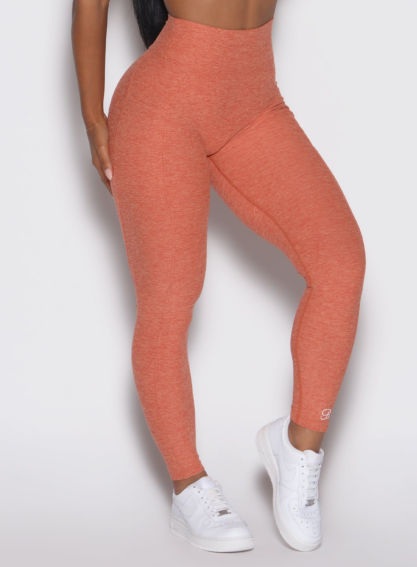 close up front right side profile view of a model wearing the Define Leggings in Spiced Maple color