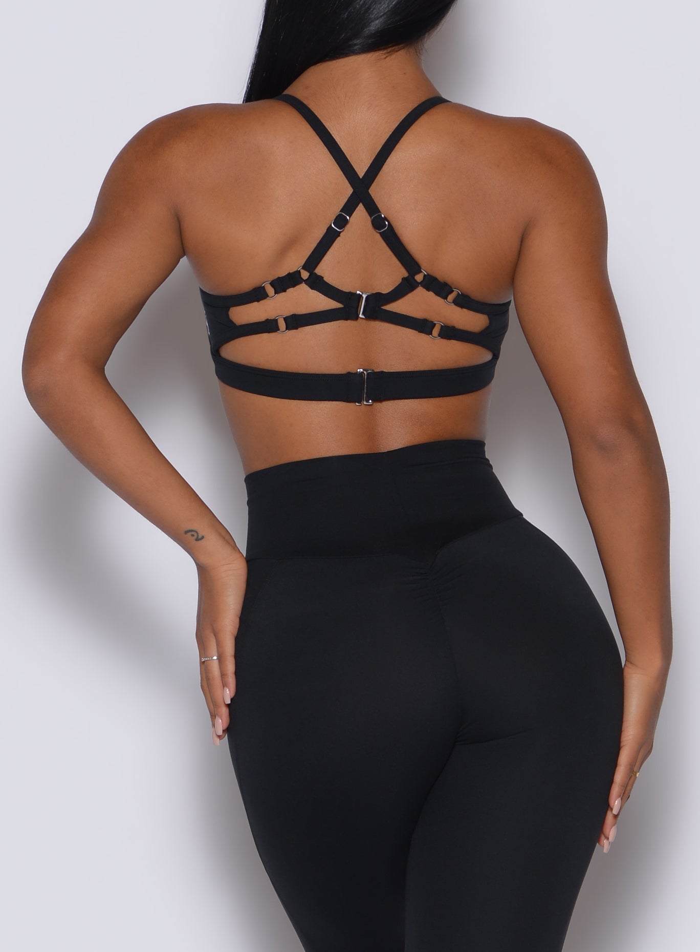 Back profile view of a model in our black Diamond sports bra and a matching leggings