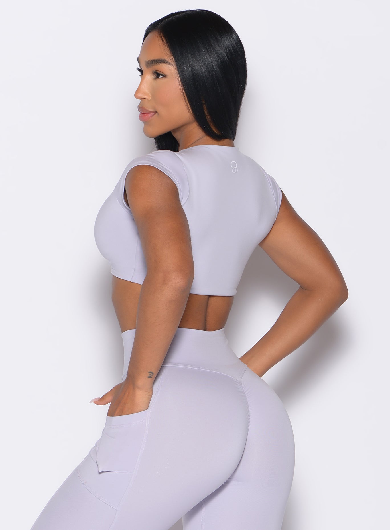 back left side profile view of a model wearing the Fab Bust Bra in galactic lilac color paired with the matching leggings