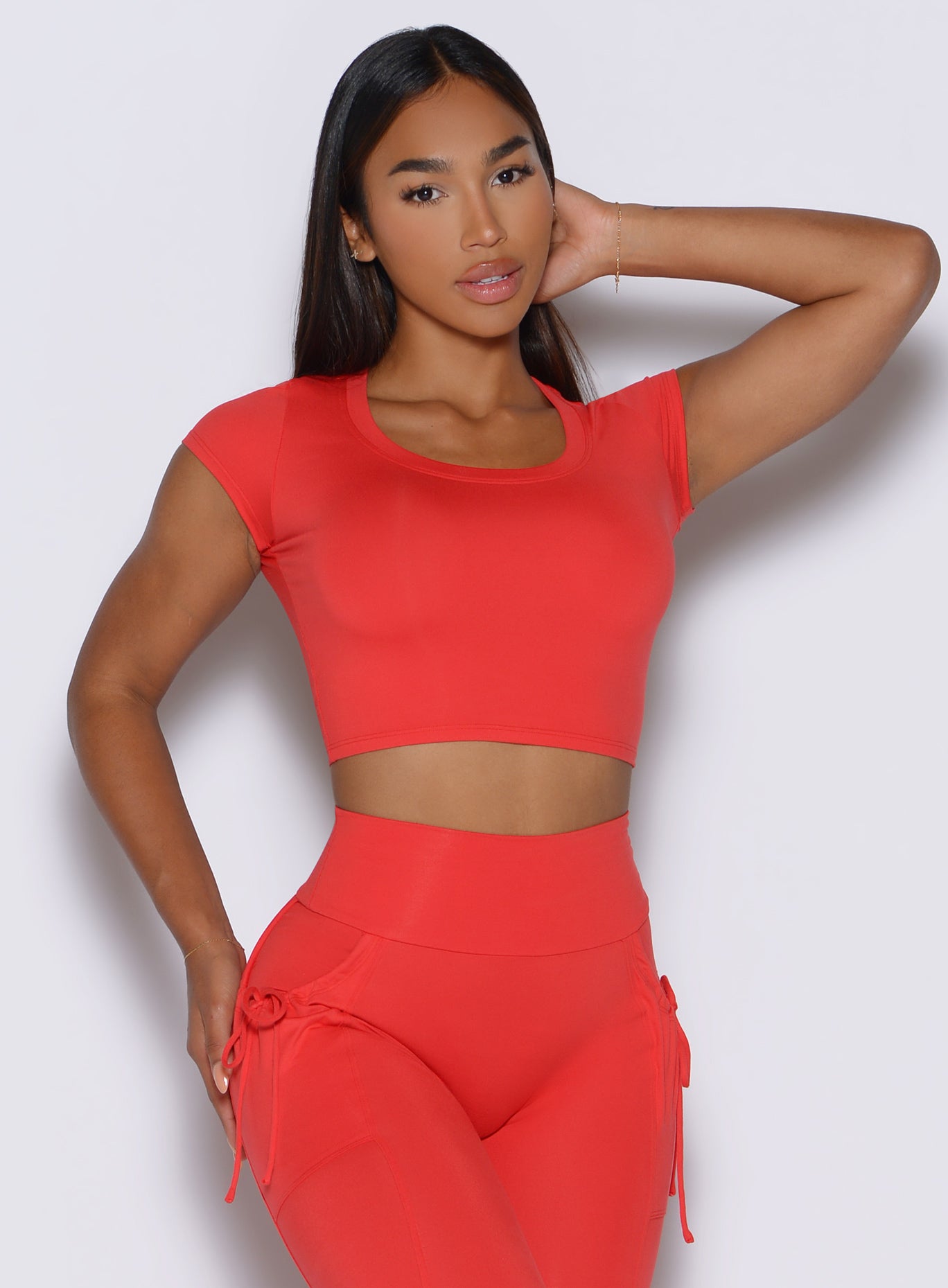 front profile view of a model wearing the FitBoost Tee in Command red color