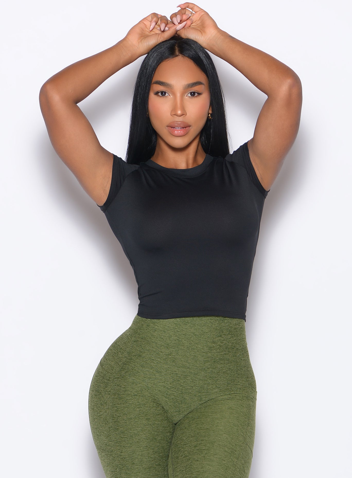 front profile picture of a model in our Flex Long Tee in Black color and the Curves 2.0 Leggings in Juniper color