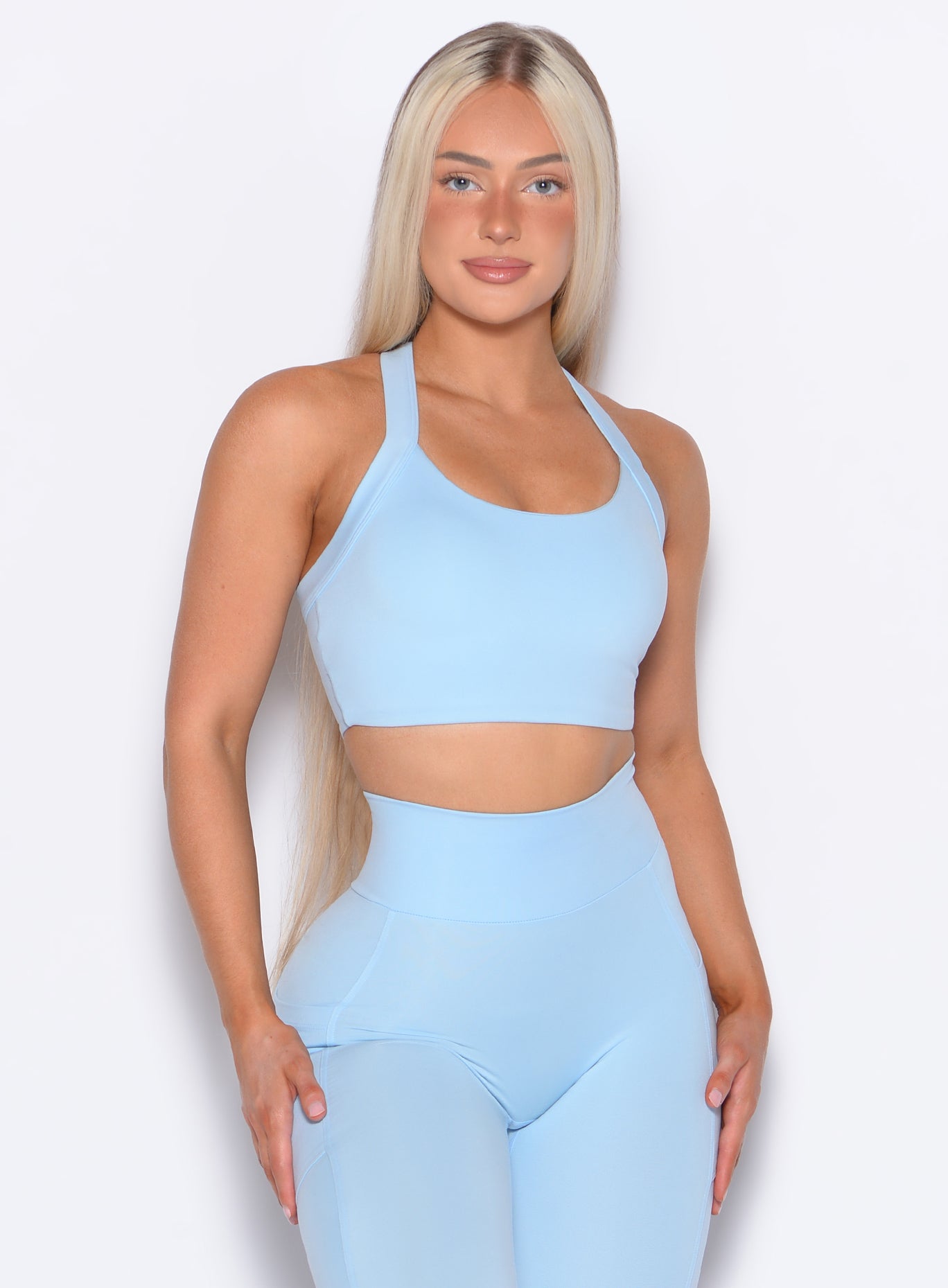 Model facing forward wearing our High Impact Bra in Glacial Blue color and the matching leggings