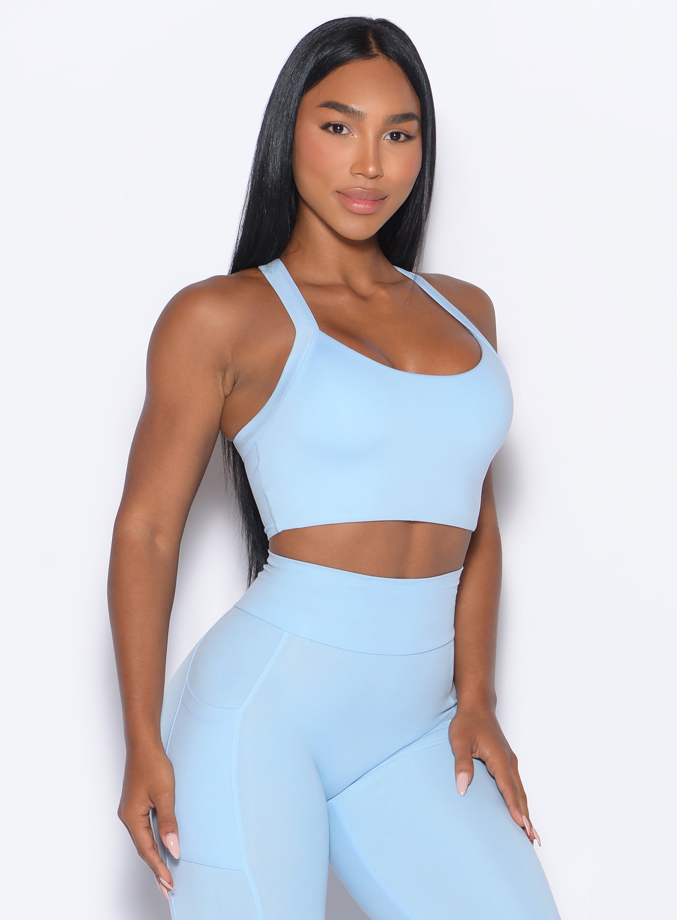 front profile picture of a model in our High Impact Bra in Glacial Blue color and the matching leggings