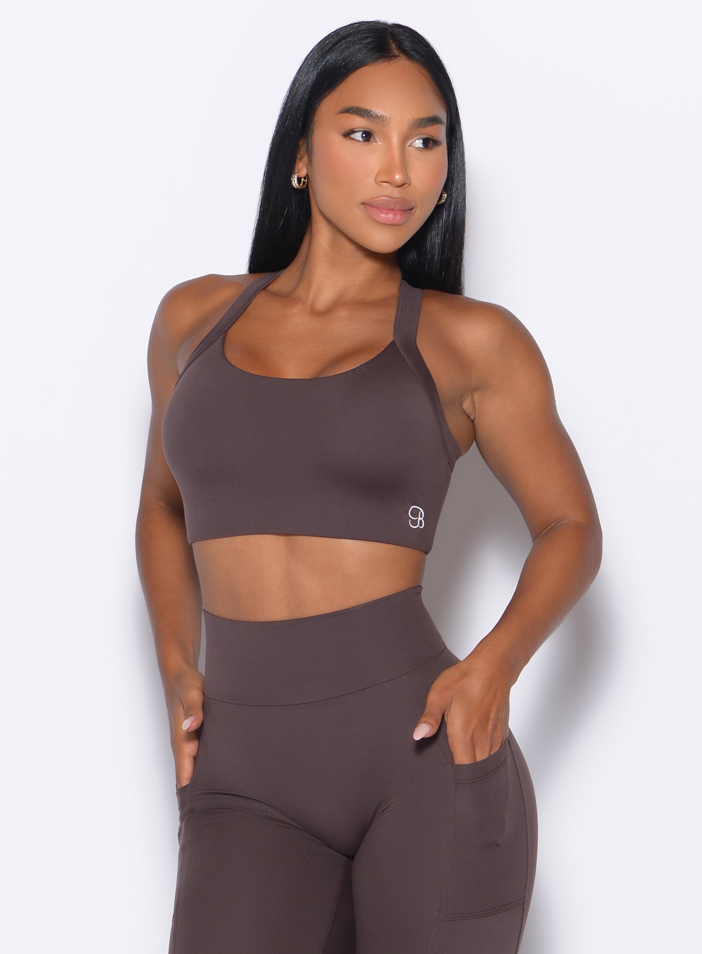 front profile view of a model wearing our High Impact Bra in Seal Brown color and the matching leggings