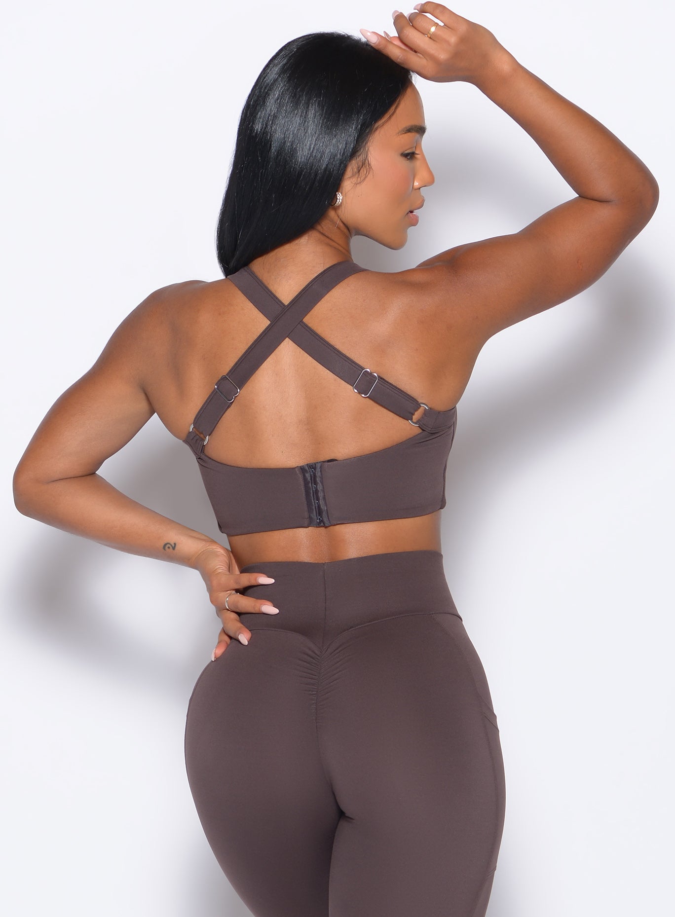 back profile of a model wearing the High Impact Bra in Seal Brown color and the matching leggings