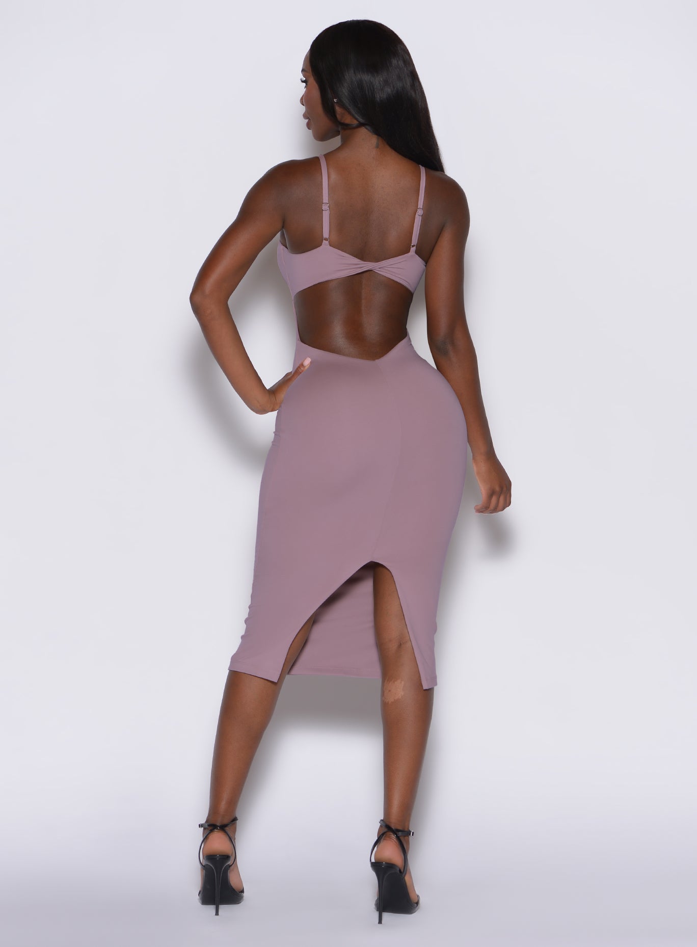 Back profile view of a model wearing our hourglass dress in light mauve color