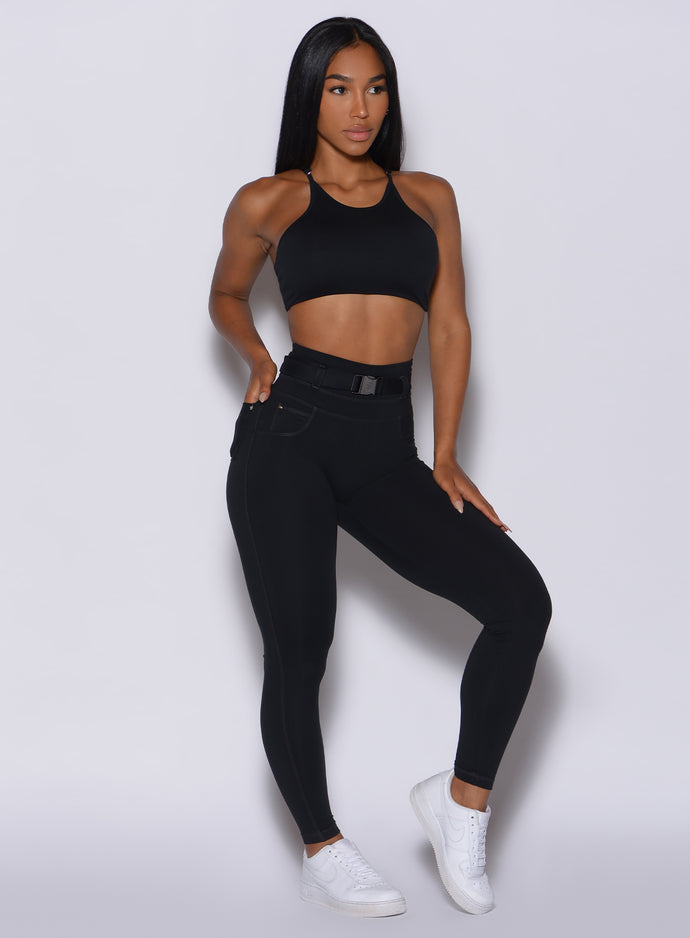 front profile view of a model wearing our black peach bottoms leggings along with the matching sports bra