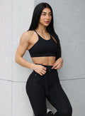 front close up profile view of a model wearing our black peach bottoms leggings along with the matching sports bra