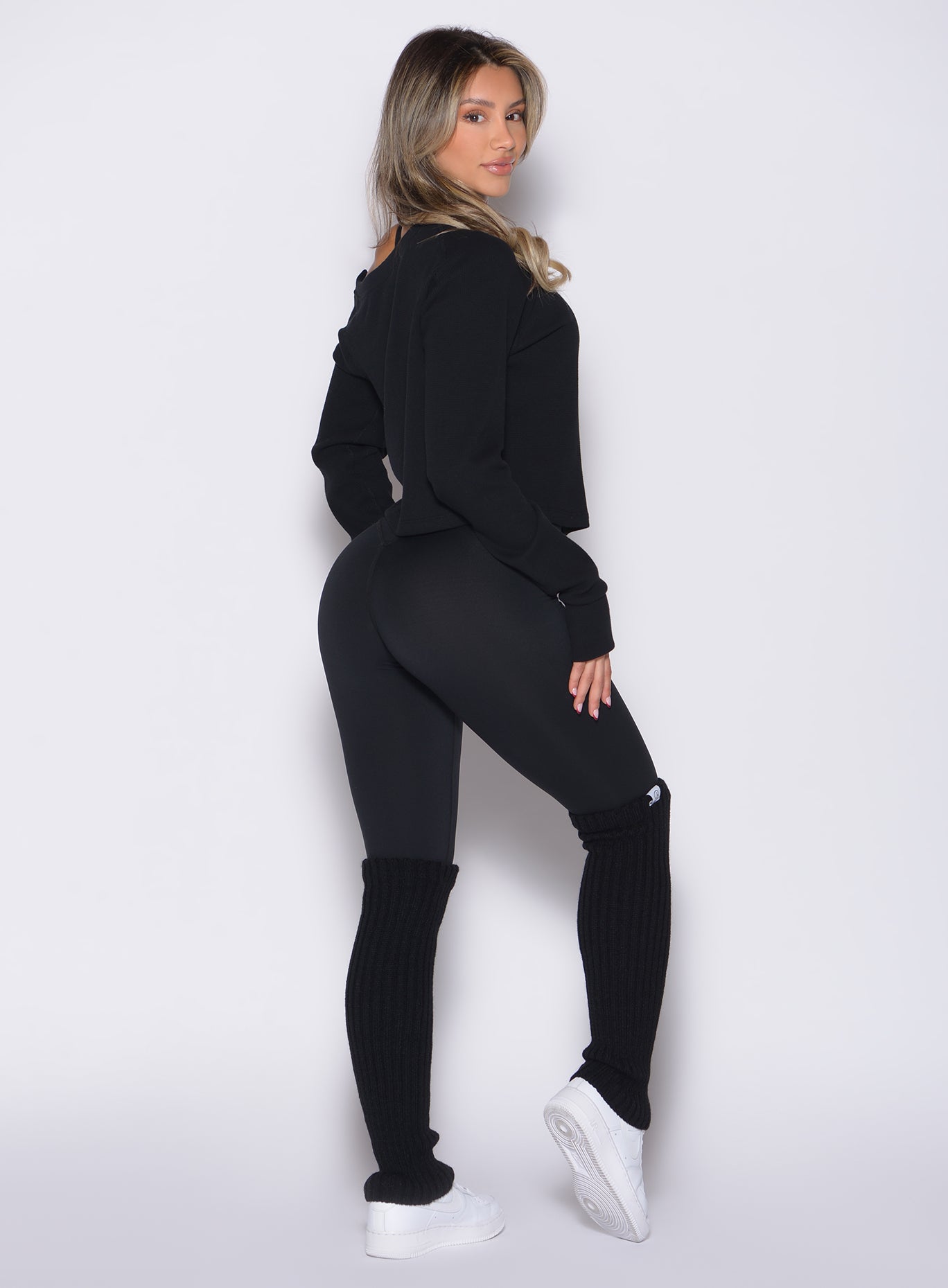 back right side profile view of a model wearing the Internal Scrunch Leggings in black color paired with the matching pullover