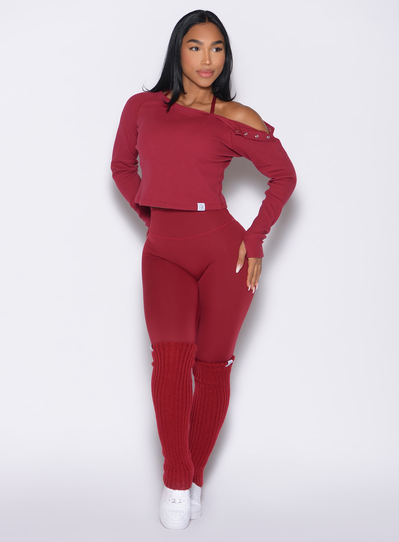 front profile view of a model looking to the left side wearing the Luxe Leg Warmers in red velvet color
