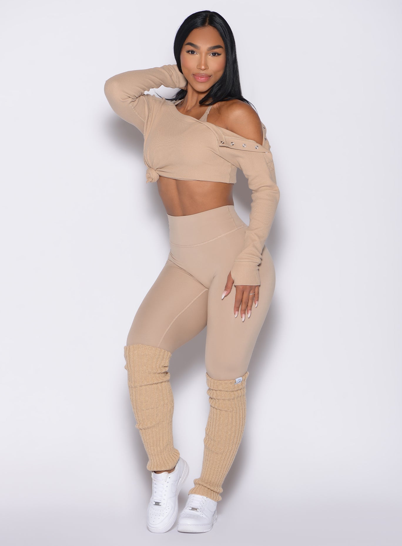 front left side profile view of a model wearing the Luxe Leg Warmers in glacial beige color
