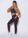 left side view of a model wearing the Line Contour Leggings in black orchid color paired with the matching tank