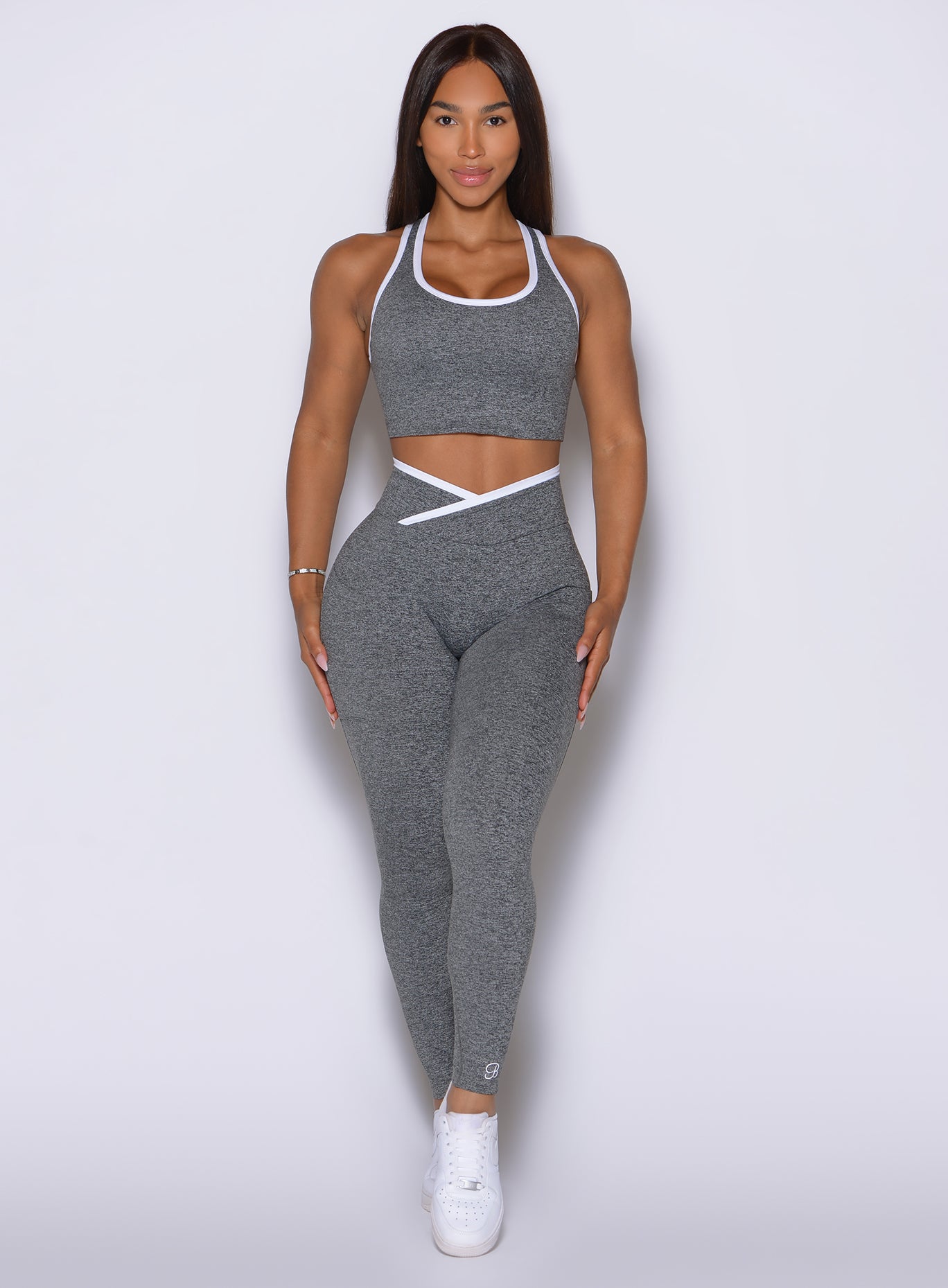 Smooth workout leggings featuring a crossover waistband, side pockets, and bold white detailing