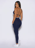 back left side profile view of a model looking over her shoulder wearing the Line Contour Leggings in navy color
