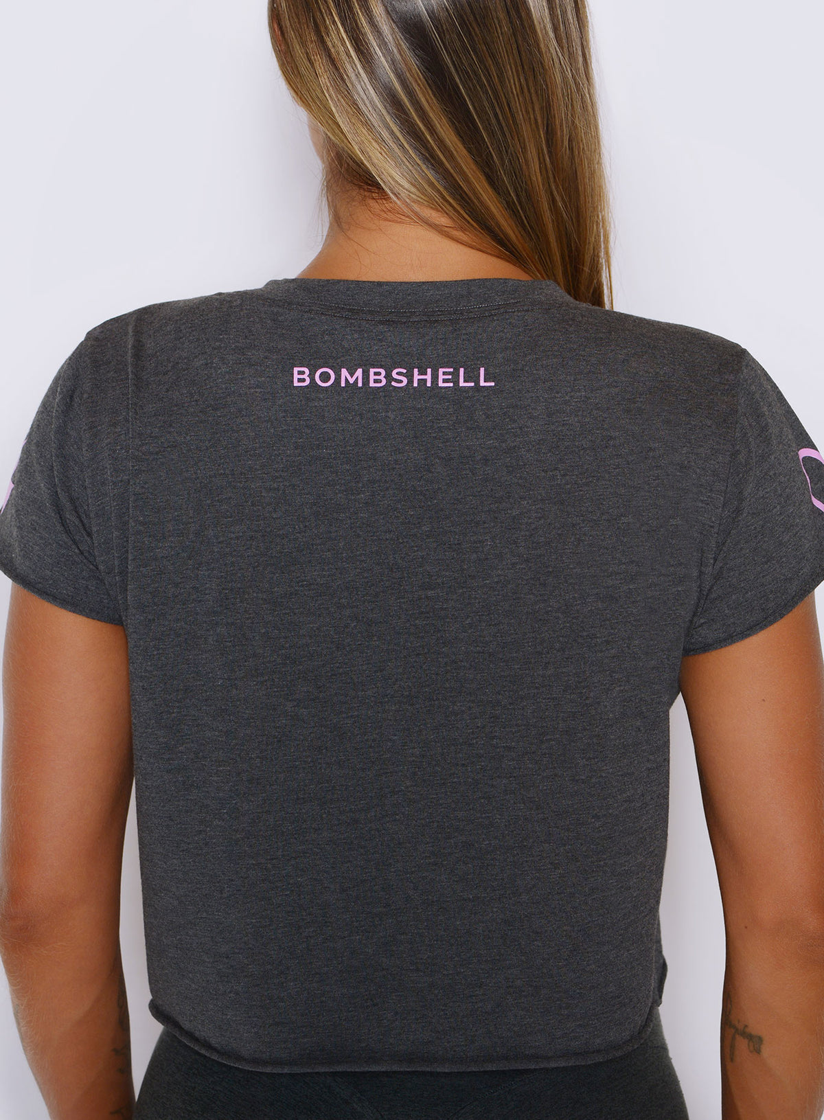 Back view of The Lover Fighter Tee in Charcoal highlighted by signature pink Bombshell logo.