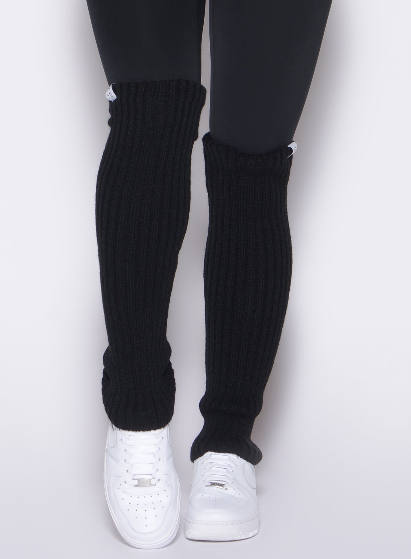 Plush black Luxe Leg Warmers with secure internal elastic for cozy, stay-put gym layering.