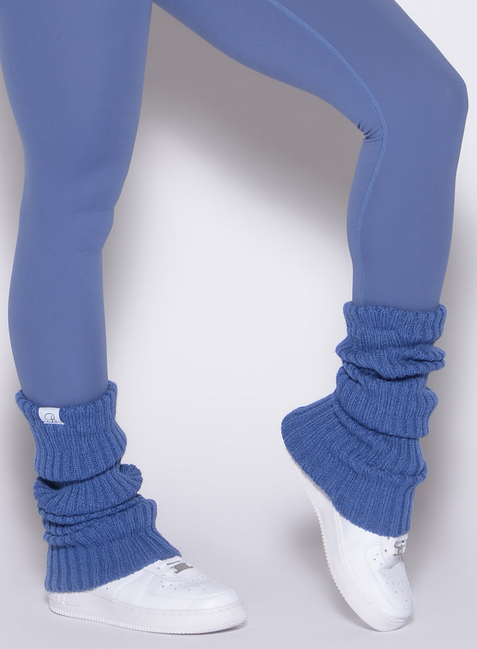 close up front right side profile view of a model wearing the Luxe Leg Warmers in blue chill color