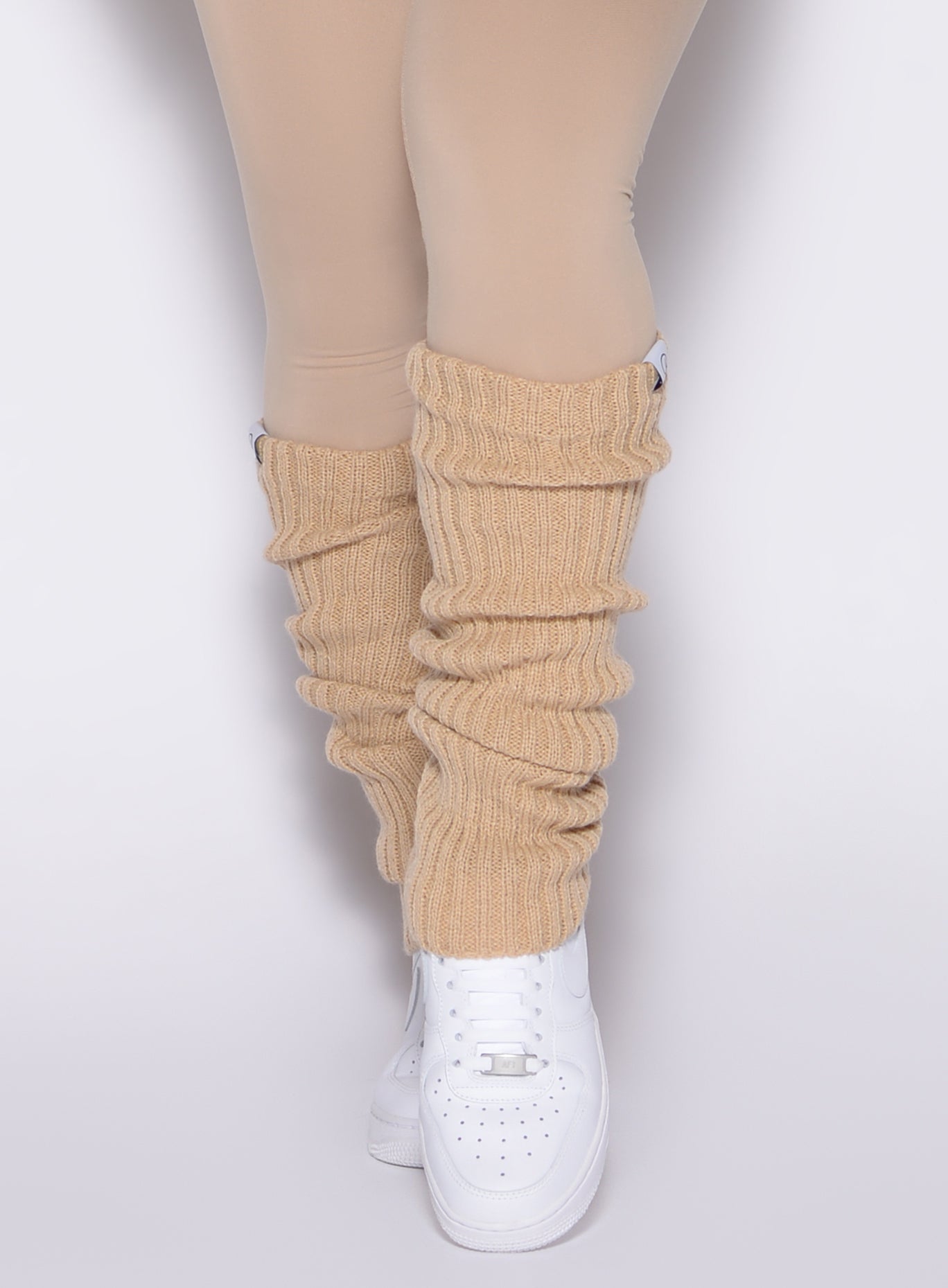 close up front view of a model wearing the Luxe Leg Warmers in glacial beige color