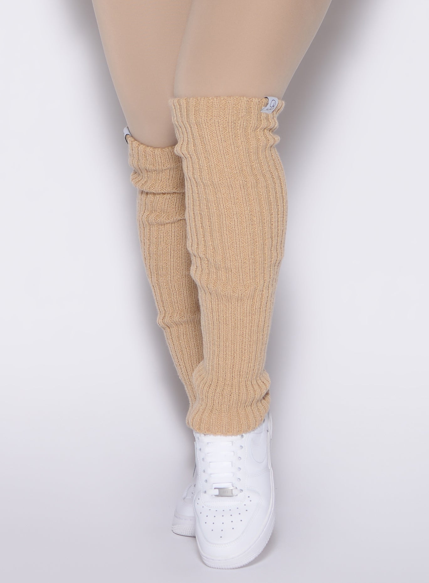 close up front view of a model wearing the Luxe Leg Warmers in glacial beige color