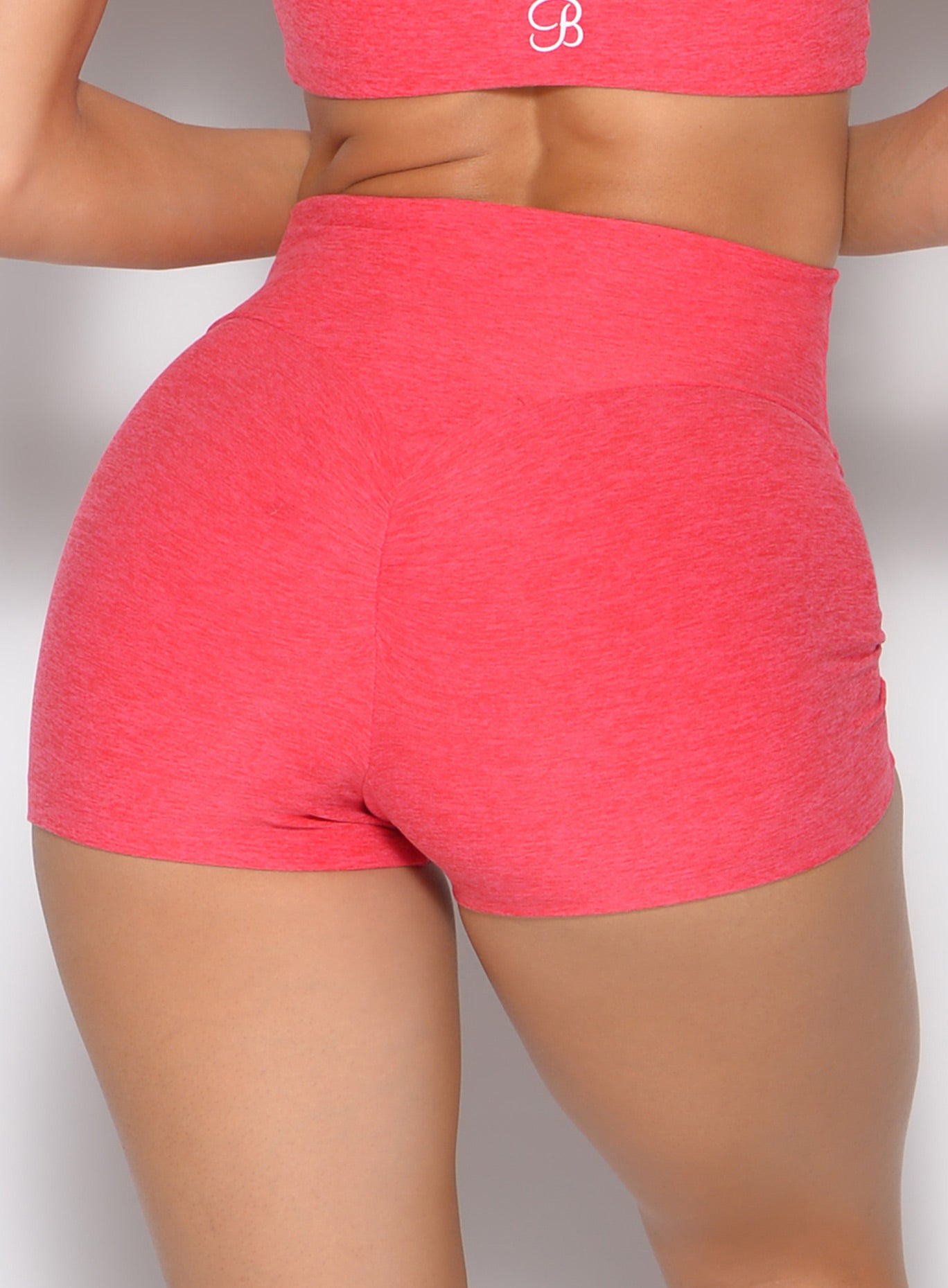 close up back profile view of a model wearing the Movement Short Shorts in watermelon punch color