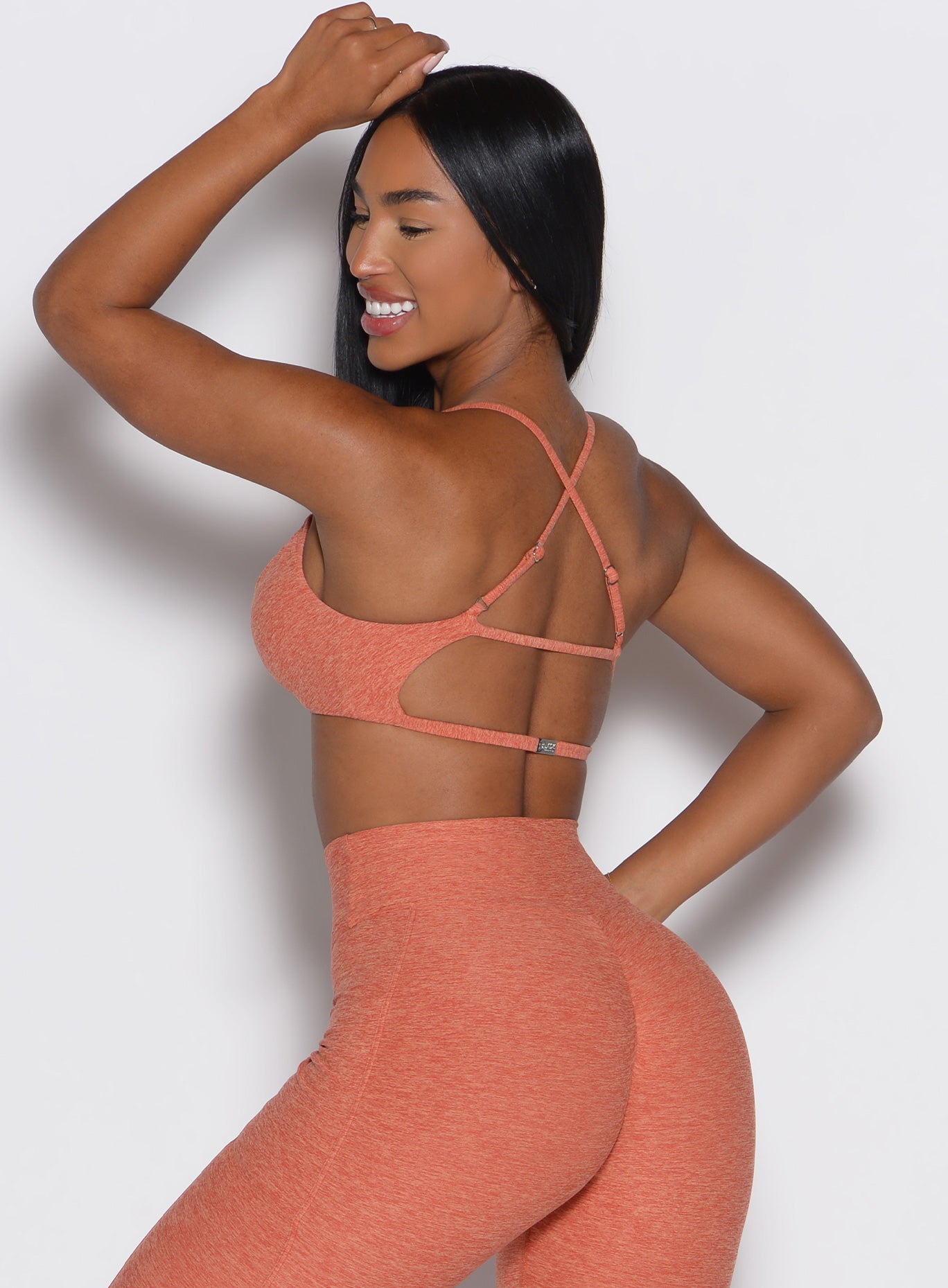 back left side profile view of a model wearing the MulTie Sports Bra in spiced maple color