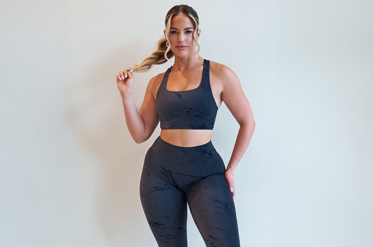 Close up image of model wearing the square neck bra and fit marble leggings in thunder gray