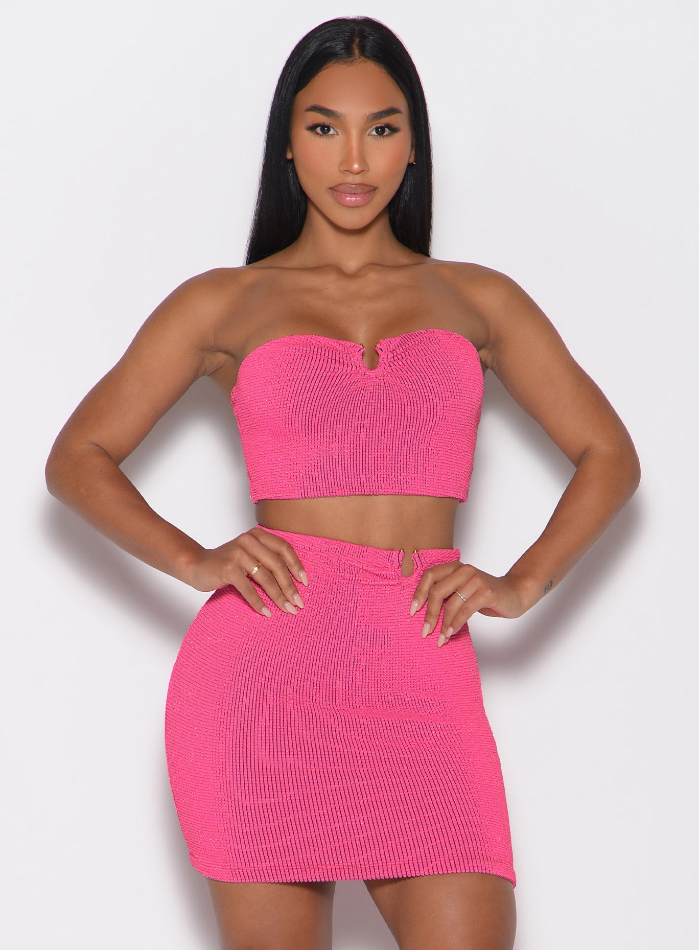 front profile view of a model with both hands on her waist wearing the Neon Nights Bikini Bandeau in Pink Passion color