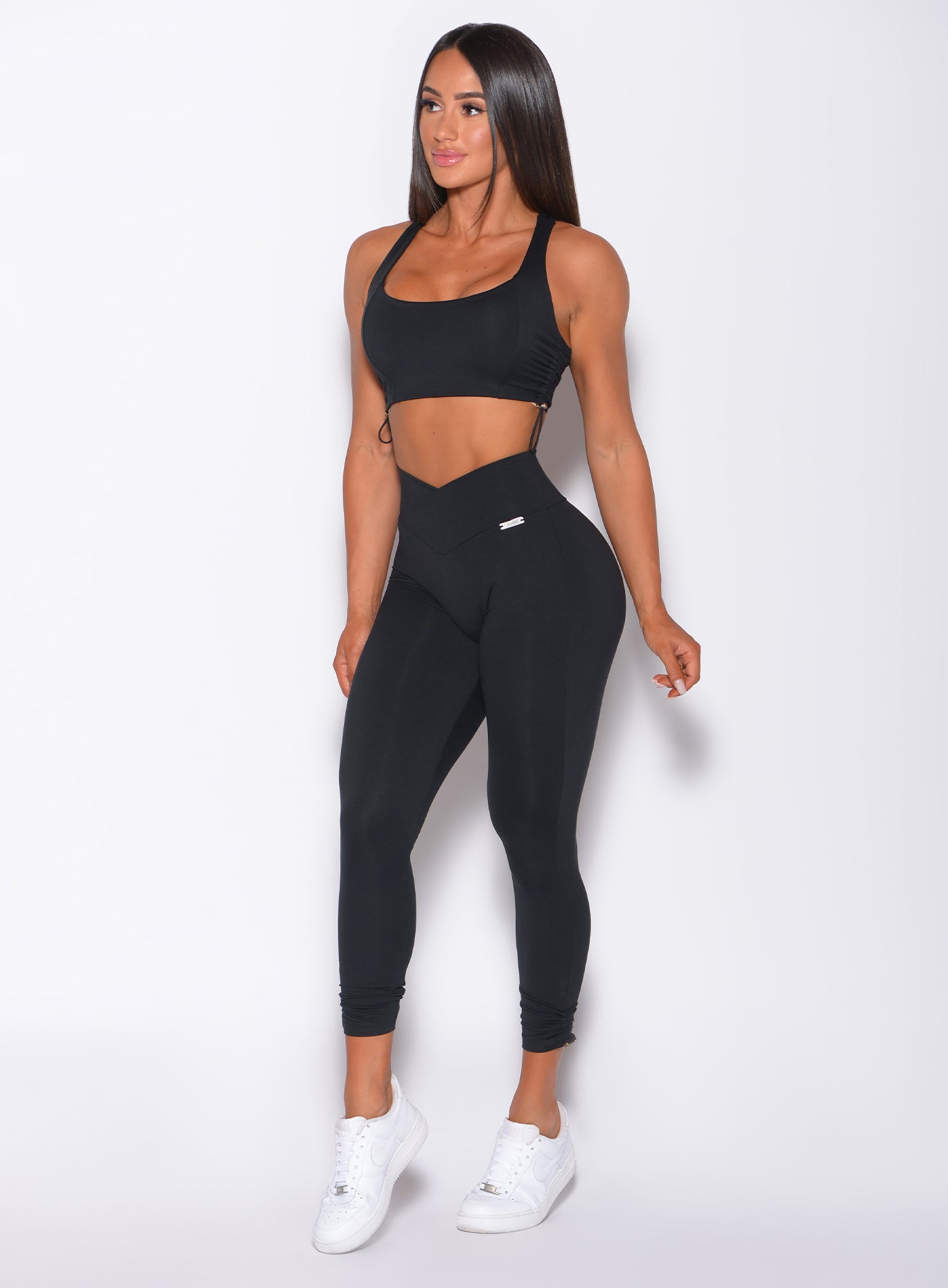 Front profile view of a model in our black toggle leggings and a matching bra